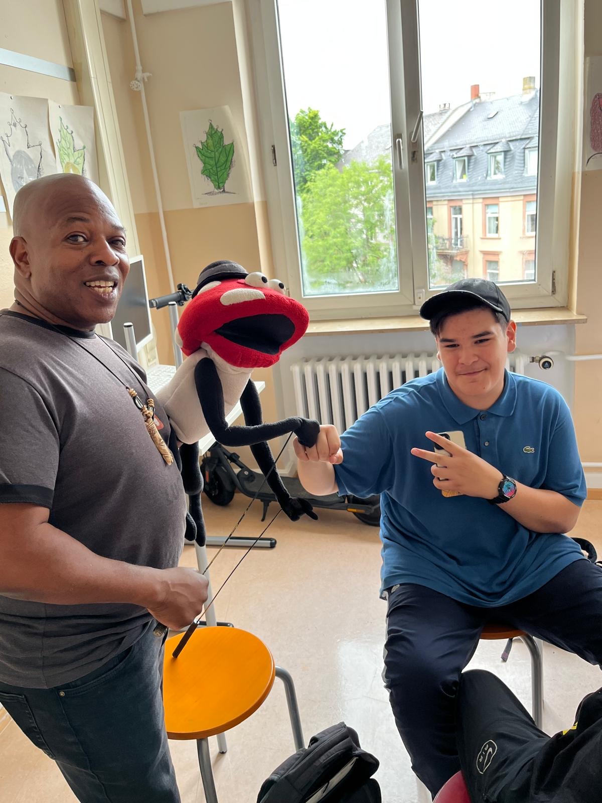 Leonard and Lucky the mushroom puppet fist-bumping a student in class